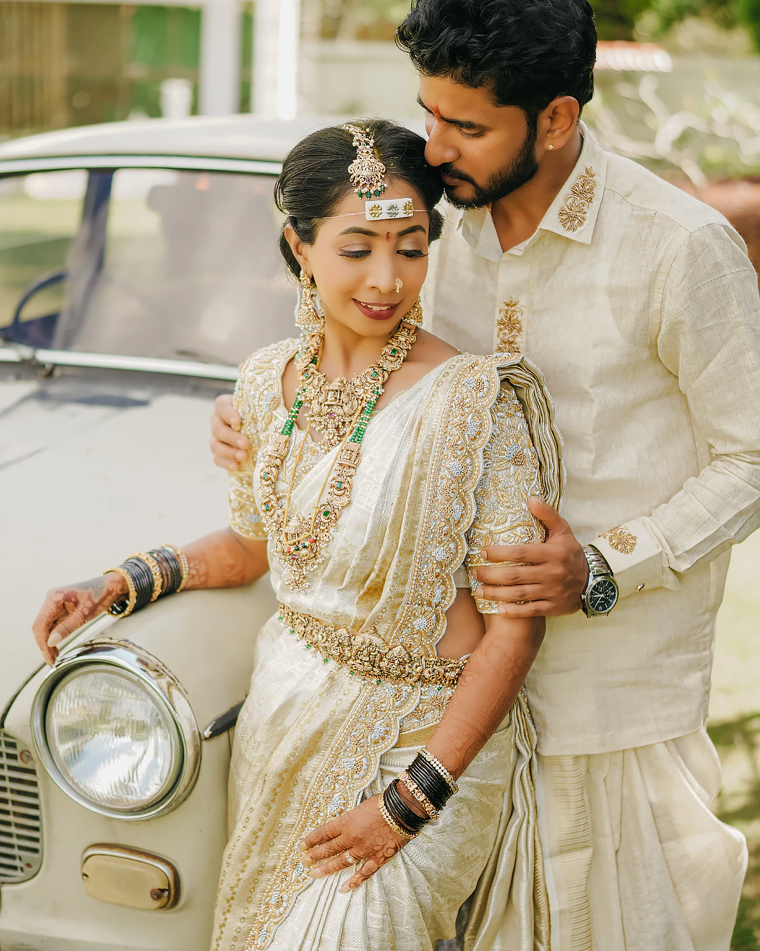 Rashmitha and Ullas beside a vintage car after their ceremony